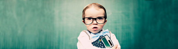 Young child wearing large glasses and holding a calculator.
