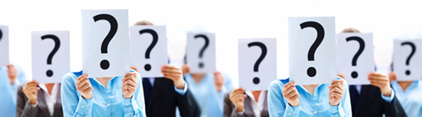 A group of women in business attire holding signs with question marks on them in front of their faces.