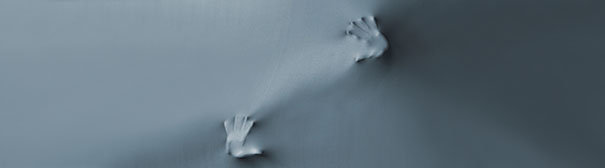 Photo of hands pushing against a wall